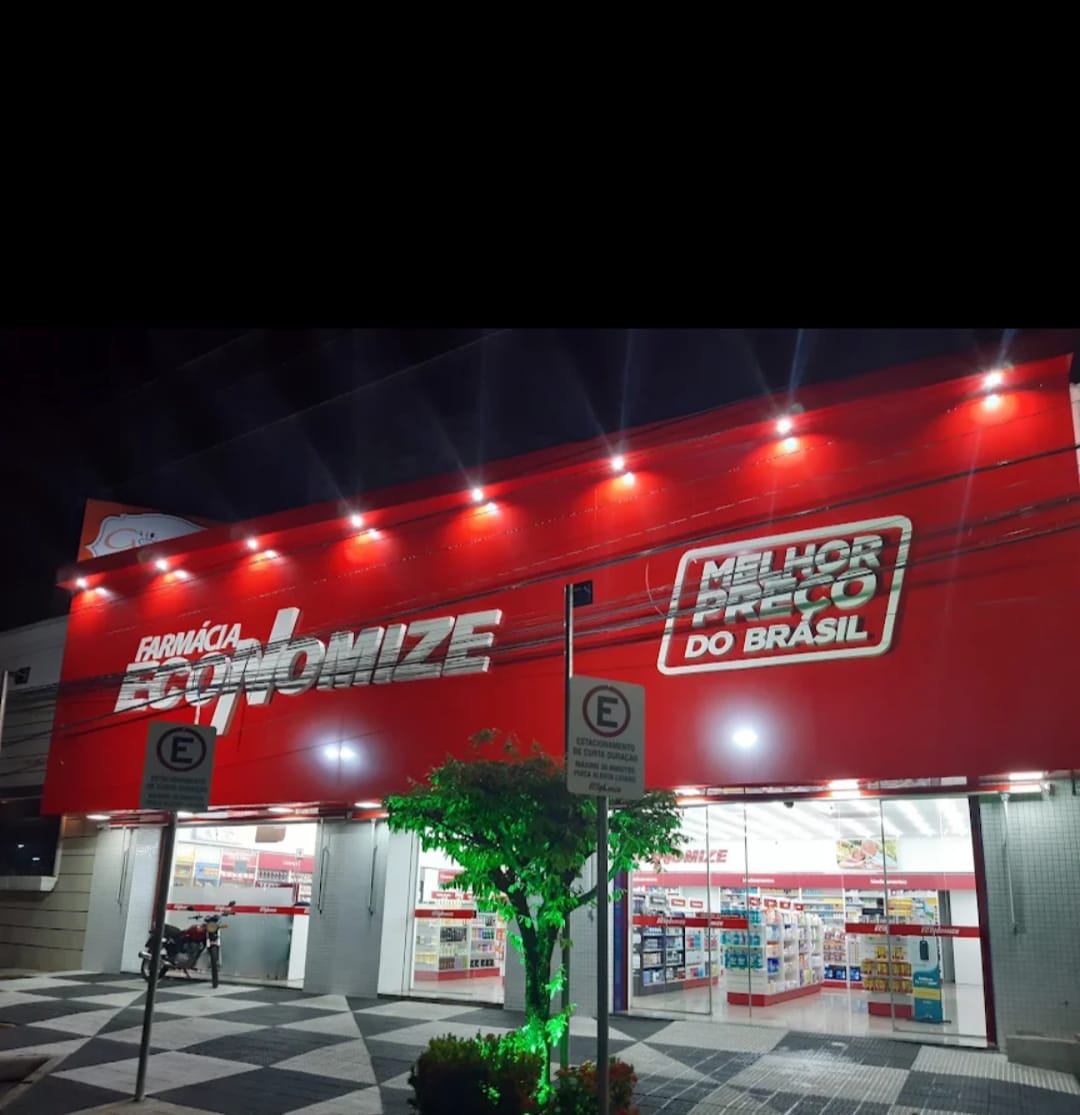 Fachada iluminada da Farmácia Economize